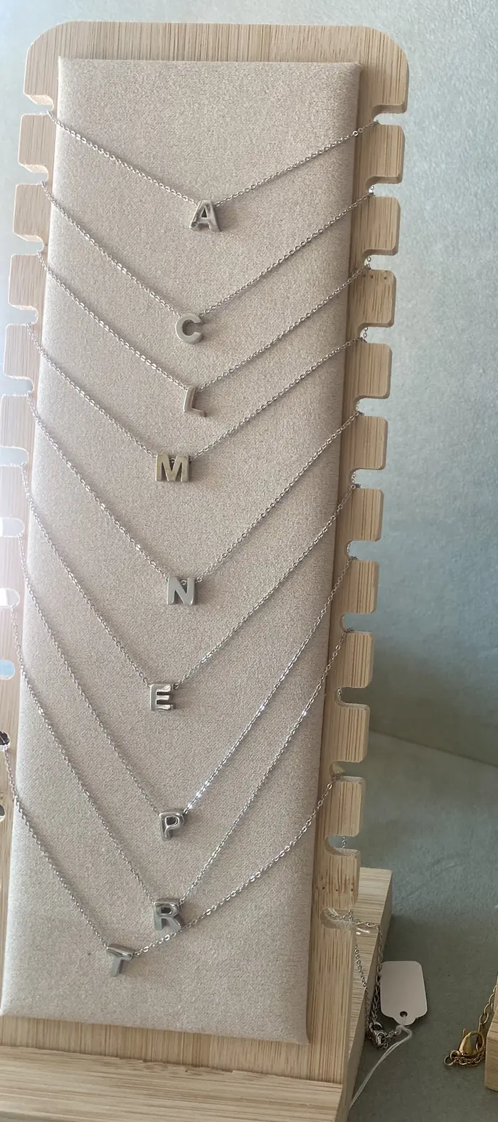 Collares con letras en plata colgados en fila